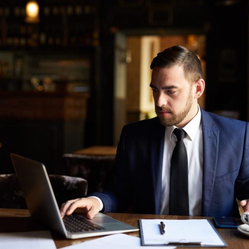 busy-man-using-laptop-in-cafe-PX5GAKJ.jpg